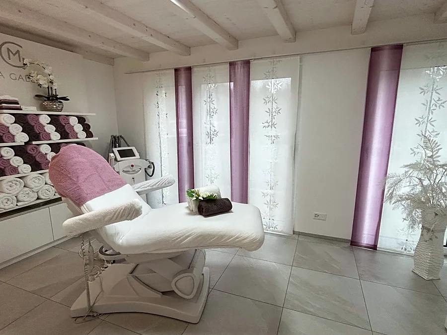 Behandlungskabine mit Liege und Vorhängen in Mauve